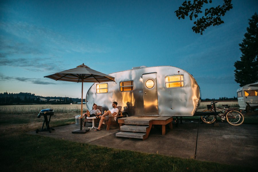 Silver caravan and chairs at dusk on a holiday pitch